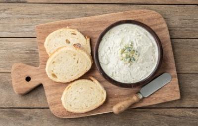 Tabla con rodajas de pan para esparcir salsa gorgonzola