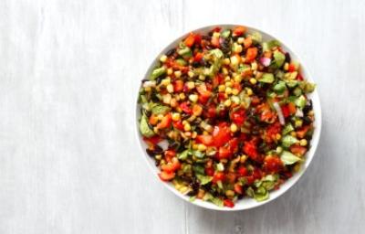 Ensalada marroquí colorida con tomate, maíz, pimiento y hierbas frescas