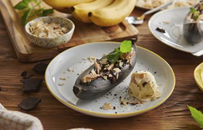 Dulce de plátano entero al horno con cáscara y helado Plátano al horno entero y con cáscara, almendras y acompañado de helado, versión del dulce de plátano