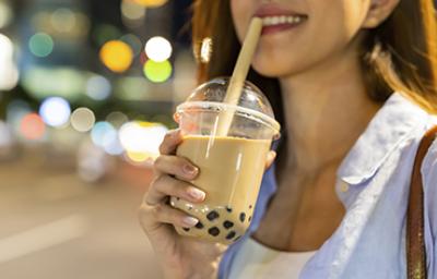 Mujer disfrutando de una bebida complementada con perlas de tapioca.