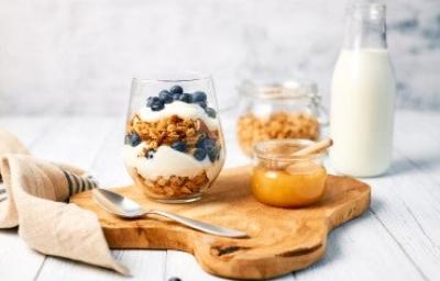 Desayuno saludable para alimentarse bien dentro y fuera de casa. Granola con yogurt griego y miel para alimentarse saludablemente.