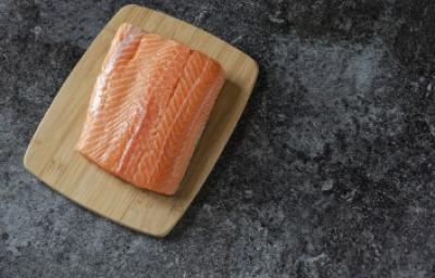 Filete de salmón fresco, uno de los tipos de salmón más usados Filete de salmón fresco sobre tabla de madera