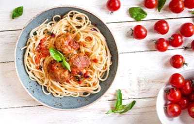 Plato de espaguetis con albóndigas en salsa de tomate, perfecto para acompañar con ají cacho de cabra