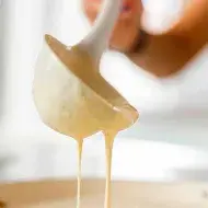 Una mujer preparando panqueques con un cucharón