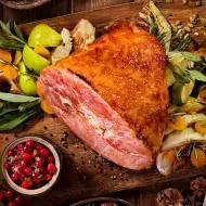 Un jamón de pavo acompañado de diferentes guarniciones navideñas.