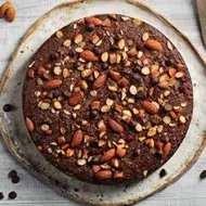 Torta de chocolate decorada con almendras sin pelar enteras y trituradas 