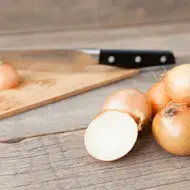 Cebollas sobre una mesa, listas para cortar en julianas o rodajas. 