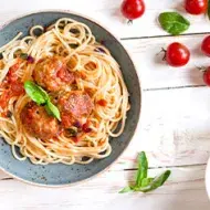 Plato de espaguetis con albóndigas en salsa de tomate, perfecto para acompañar con ají cacho de cabra