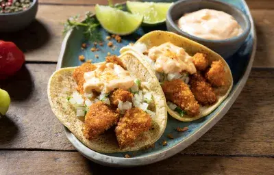 Tacos de maíz con pollo crunchy empanizado, cebolla, cilantro y salsa chipotle cremosa