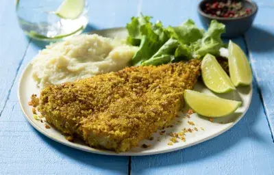 Filete de pescado crocante con costra pimienta limón, puré de papas cremoso MAGGI y gajos de limón