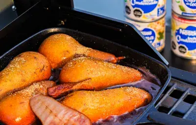 Peras al vino tinto con leche condensada, hechas en una sarten de fierro sobre la parrilla. Postre para asado familiar