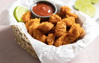 Chicken pops crujientes en cesta, pechuga en cubos con sazonador Chipotle Dulce y salsa para mojar