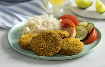 Croquetas crujientes de atún al horno, servidas con arroz blanco y ensalada de pepino y tomate