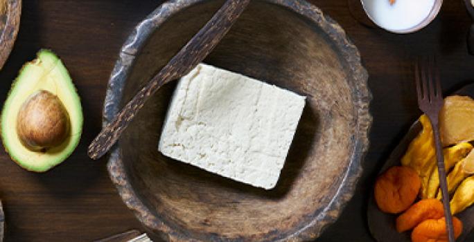Tofu, una carne vegetal, en un plato de madera. Tofu, una carne vegetal, en un plato de madera.