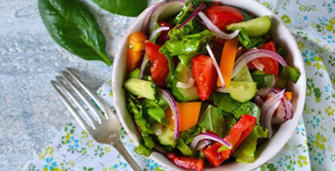 Las ensaladas son comidas fáciles de hacer con verduras. Ensalada con base de hojas verdes, con zanahoria y cebolla, una comida fácil de hacer.