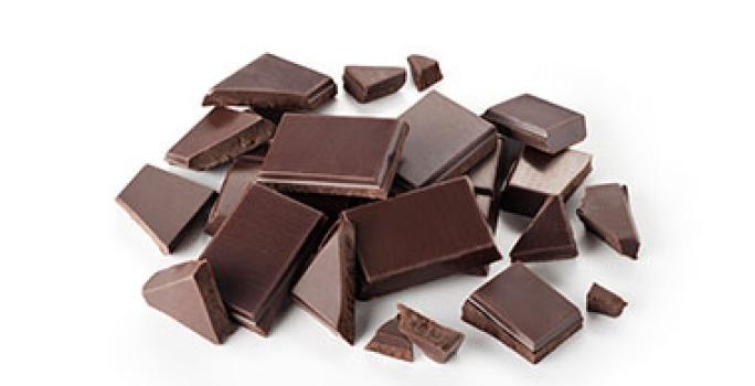 El chocolate negro que no se prepara con leche es parte de las comidas veganas. Trozos de chocolate negro, que no contiene leche, apto para comidas veganas.