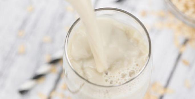 Las leches vegetales con una muy buena opción vegana. Leche de avena en un vaso, una alternativa vegana para remplazar la leche de origen animal.