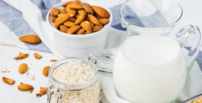 Leche y harina con tazón de almendras enteras sin pelar Leche y harina con tazón de almendras enteras sin pelar
