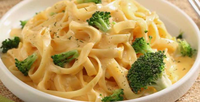 Plato de receta con tallarines en salsa de queso y brócoli Plato de receta con tallarines en salsa de queso y brócoli
