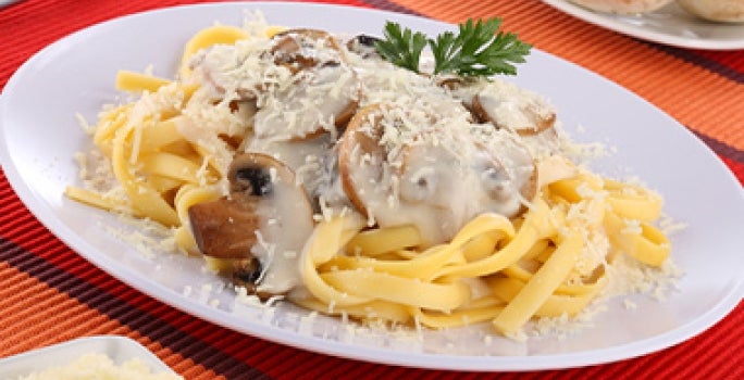 Plato de recetas con tallarines con salsa de champiñones Plato de recetas con tallarines con salsa de champiñones