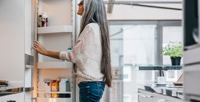 Mujer abriendo puerta de refrigerador, quitar mal olor del refrigerador Mujer abriendo puerta de refrigerador, quitar mal olor del refrigerador