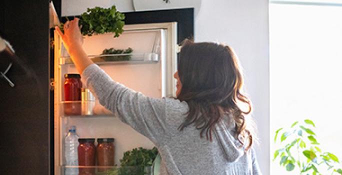 Mujer sacando ingrediente de refrigerador, quitar mal olor del refrigerador Mujer sacando ingrediente de refrigerador, quitar mal olor del refrigerador