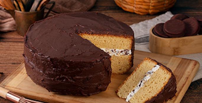 Mesa con torta de cumpleaños de vainilla con cobertura de chocolate Mesa con torta de cumpleaños de vainilla con cobertura de chocolate