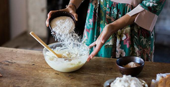 Mujer añadiendo harina a su mezcla de crema pastelera. Mujer añadiendo harina a su mezcla de crema pastelera.