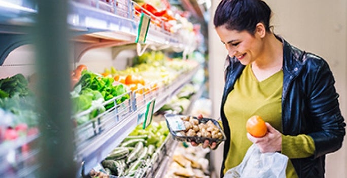 Mujer comprando champiñones y frutas supermercado clasificación alimentos Mujer comprando champiñones y frutas supermercado clasificación alimentos
