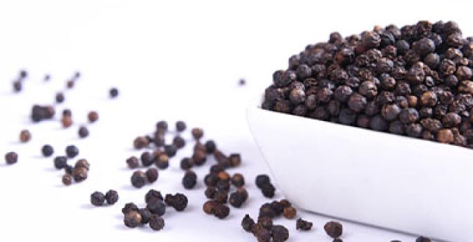 Recipiente con granos enteros de pimienta negra Recipiente con granos enteros de pimienta negra