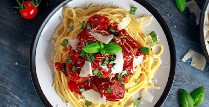 La salsa pomodoro se puede añadir al servir la pasta. Espagueti con salsa pomodoro, queso rallado y hierbas aromáticas.
