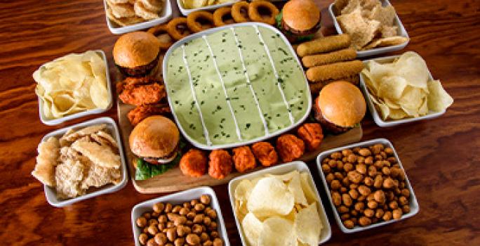 Mesa con snacks fáciles, como frutos secos y papas, para ver deportes. Mesa con snacks fáciles, como frutos secos y papas, para ver deportes.