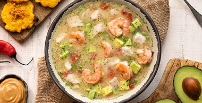 Plato de caldo de pescado con camarones, chiles, plátano y aguacate Plato de caldo de pescado con camarones, chiles, plátano y aguacate