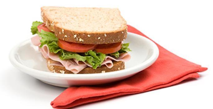 Cómo preparar un sándwich relleno jamón, tomate y lechuga Cómo preparar un sándwich relleno jamón, tomate y lechuga plato y servilleta