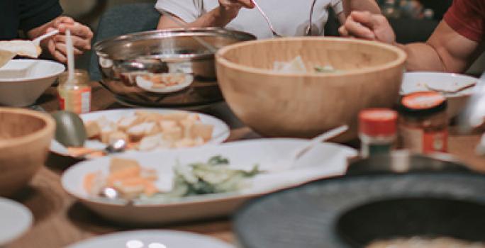 Familia compartiendo dumplings y otros platillos asiáticos Familia compartiendo dumplings y otros platillos asiáticos