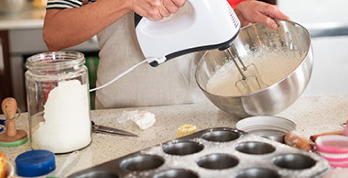 Mujer batiendo ingredientes con bicarbonato de sodio para cocinar Mujer batiendo ingredientes con bicarbonato de sodio para cocinar