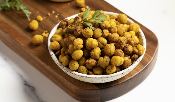 Garbanzos crocantes sazonados con Mi Sazón Maggi, servidos como snack en un cuenco