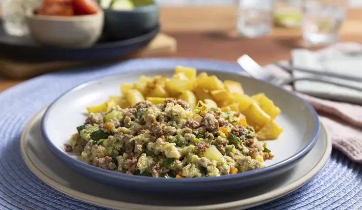 Guiso de zapallo italiano con papas doradas