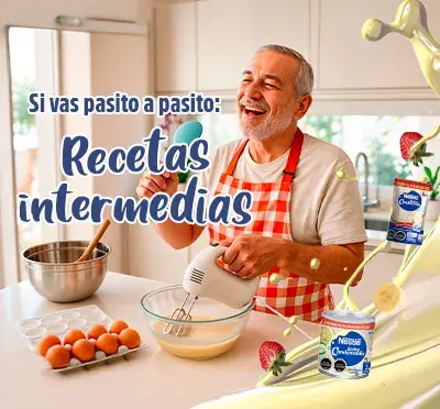 Niña y adulto cocinando juntos en cocina iluminada, con ingredientes y productos Nestlé.